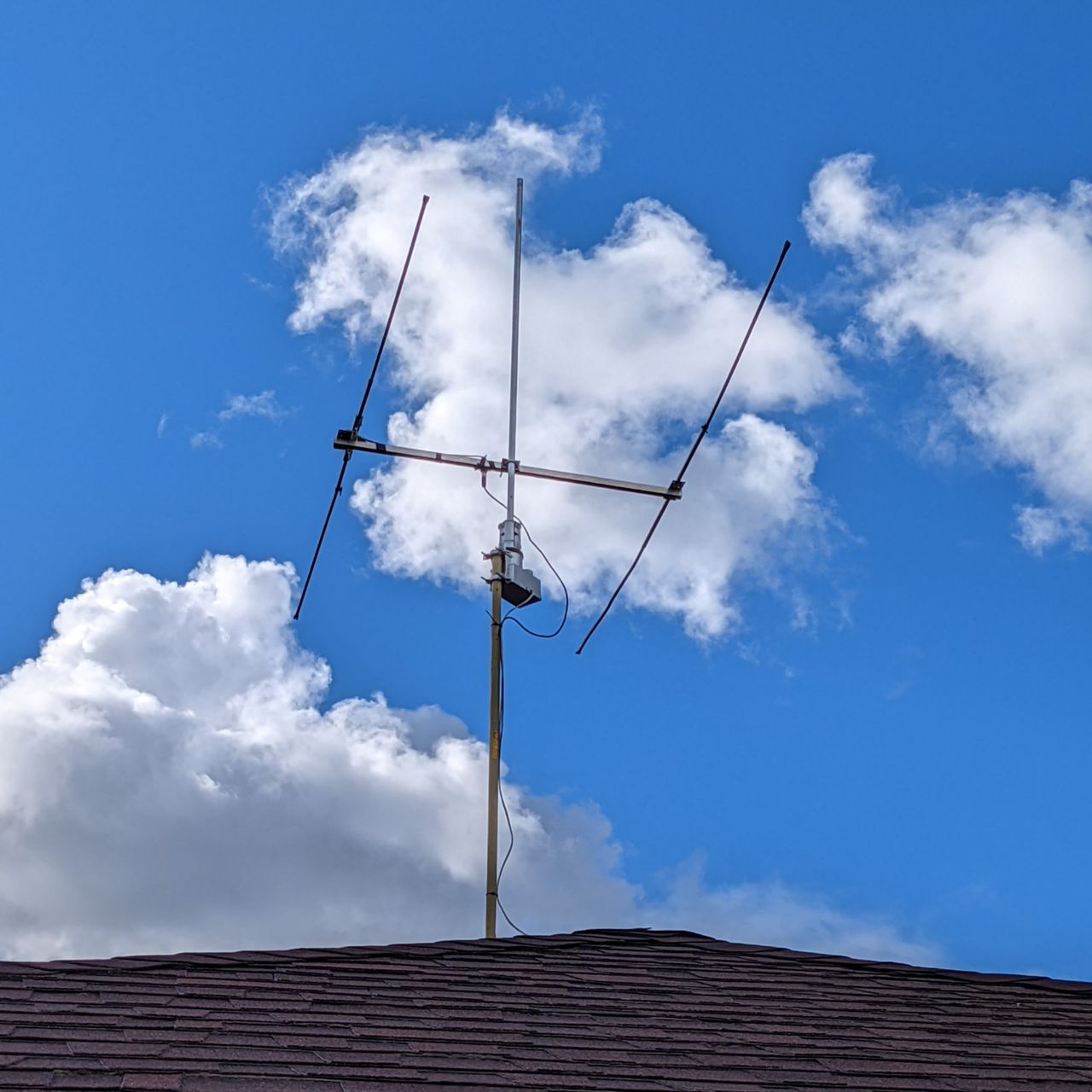 6m antenna in front of a blue sky with clouds